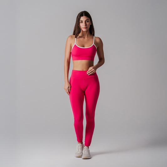 Woman wearing a fuchsia athletic outfit on a gray background