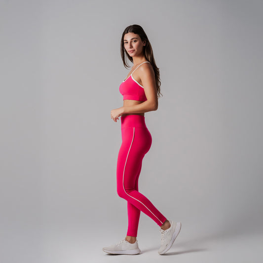 Model wearing a fuchsia athletic outfit on a gray background