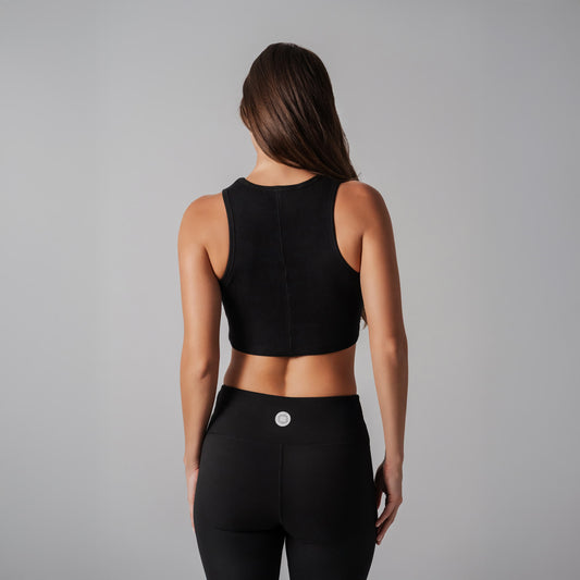 Person wearing a black athletic outfit on a gray background