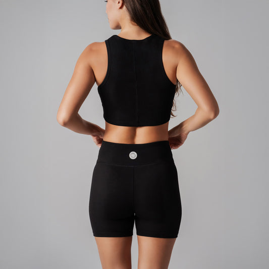 Person wearing a black athletic outfit on a gray background