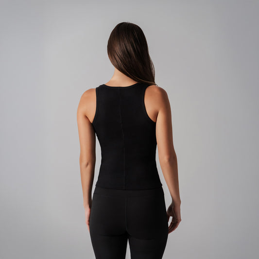 Person wearing a black sleeveless top and pants on a gray background