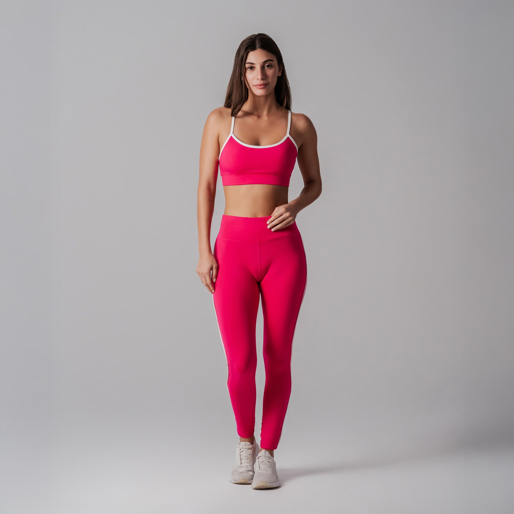 Woman wearing a fuchsia athletic outfit on a gray background