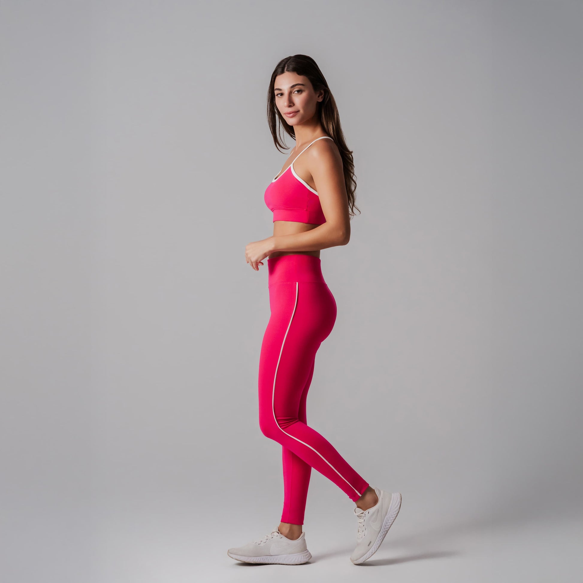 Model wearing a fuchsia athletic outfit on a gray background