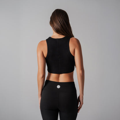 Person wearing a black athletic outfit on a gray background