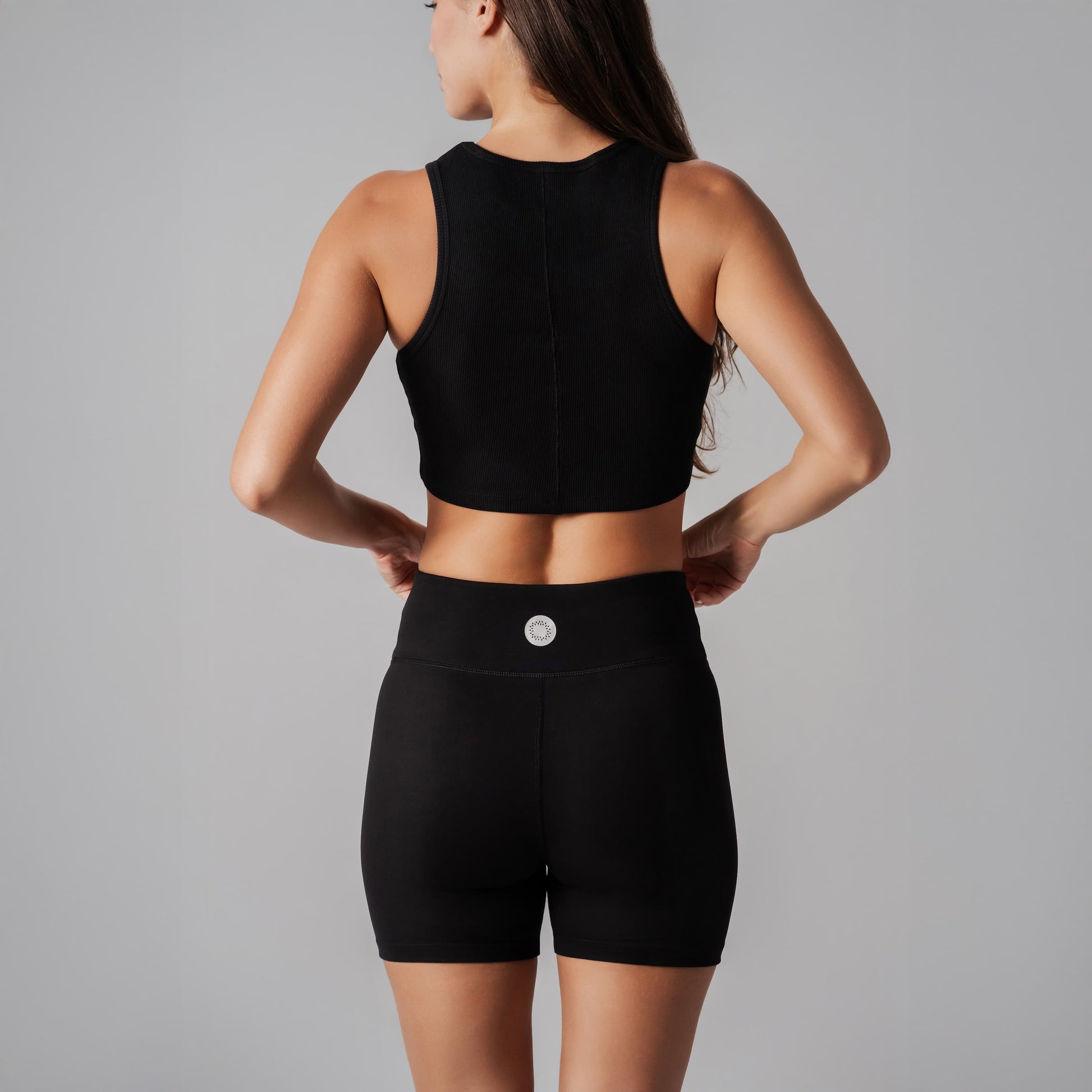 Person wearing a black athletic outfit on a gray background