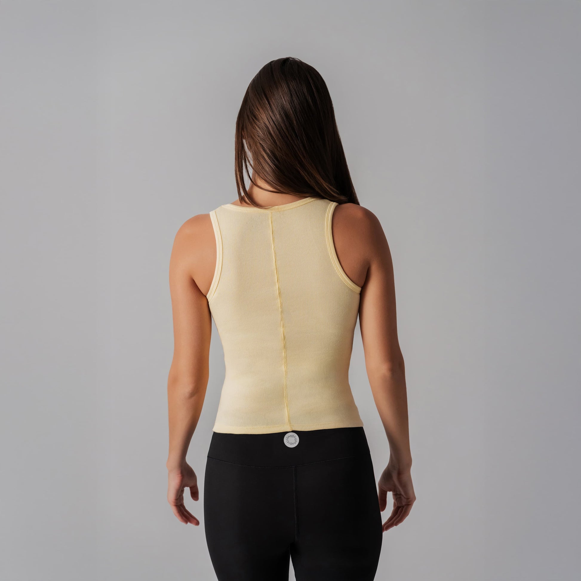 Woman wearing a beige compression garment against a gray background