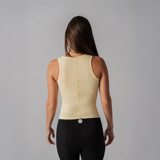 Woman wearing a beige compression garment against a gray background