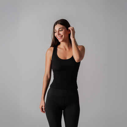 Woman wearing a black bodysuit against a gray background