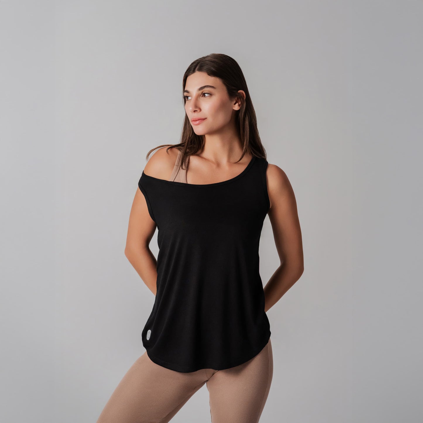 Woman wearing a black sleeveless top against a gray background