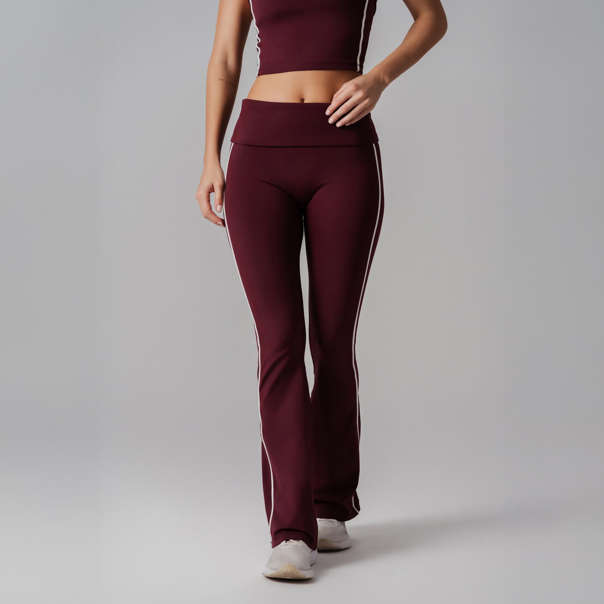 Burgundy athletic outfit with white stripes on a gray background