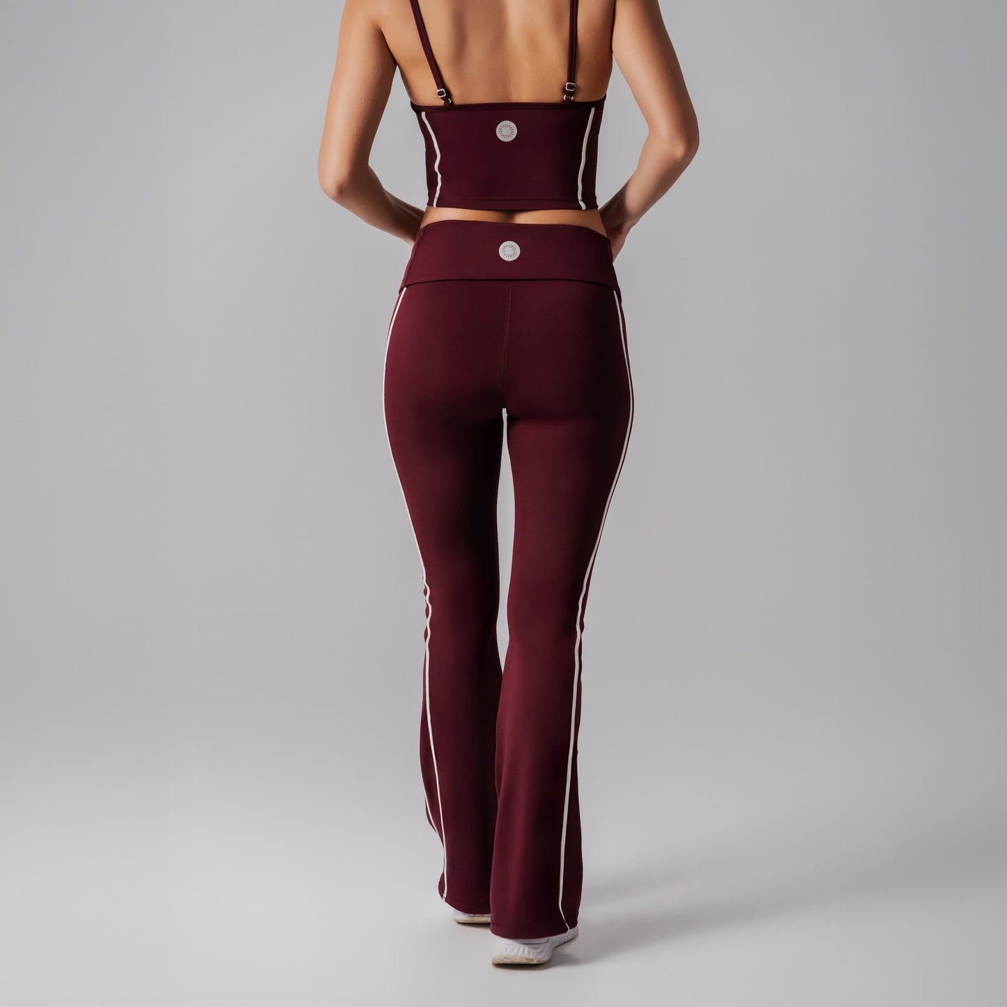 Burgundy athletic outfit with white stripes on a gray background